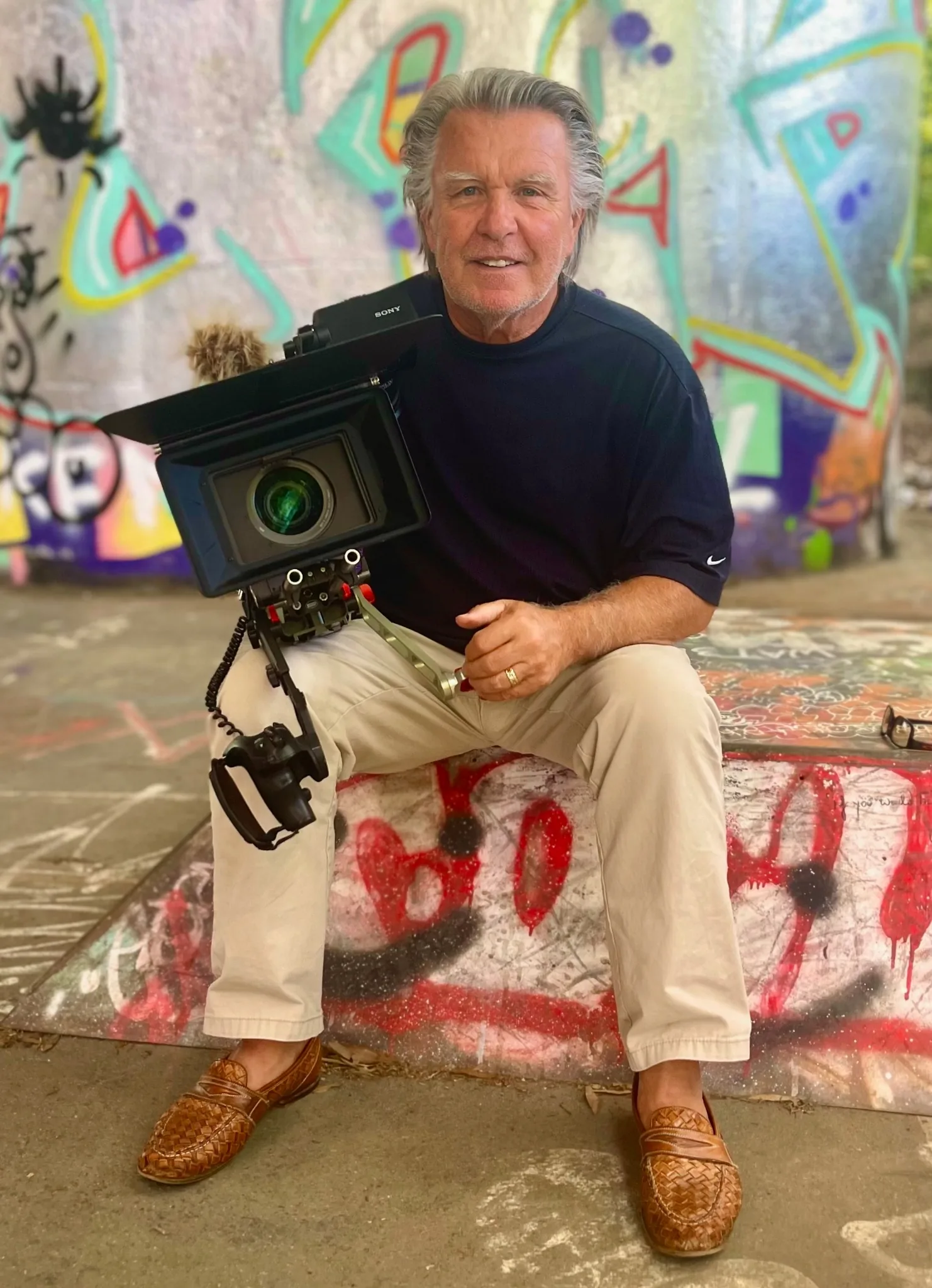 Director of photography Paul Dougherty seated with a cinema camera