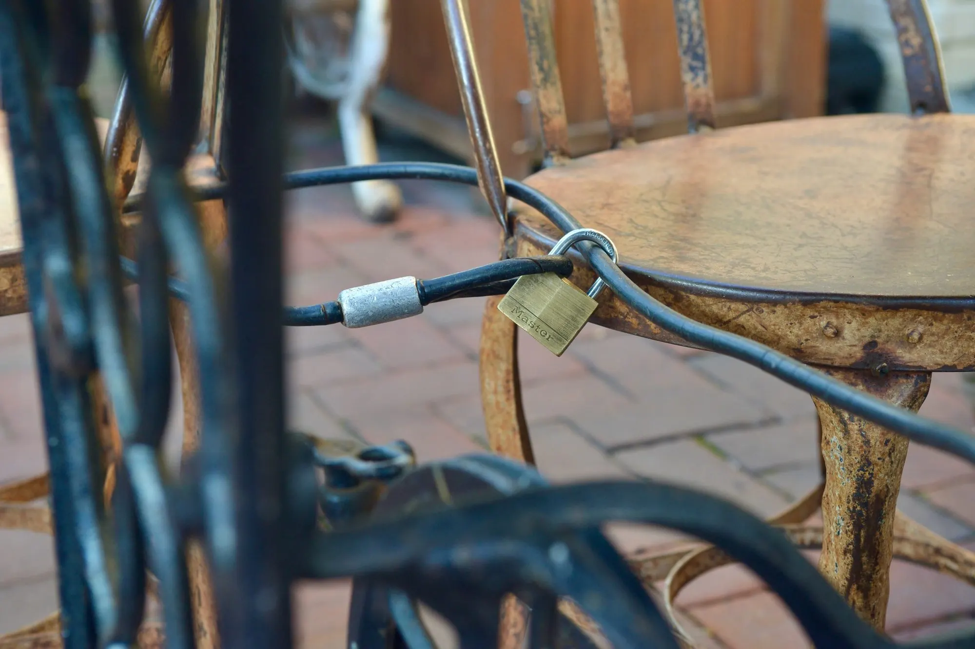 A padlock and cable securing closed café chairs